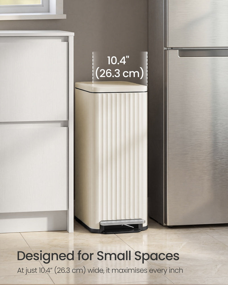 Beige pedal bin standing in a 26.3 cm gap between a white kitchen cabinet and a fridge