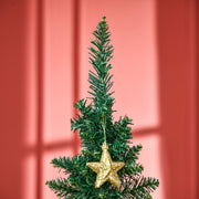 Close-up of the green tree top decorated with a gold star