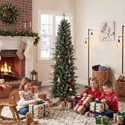 Children opening presents beside the decorated slim Christmas tree by a brick fireplace