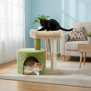 Green cat tree beside a sofa with a black cat on the top bed and a ginger cat in the condo