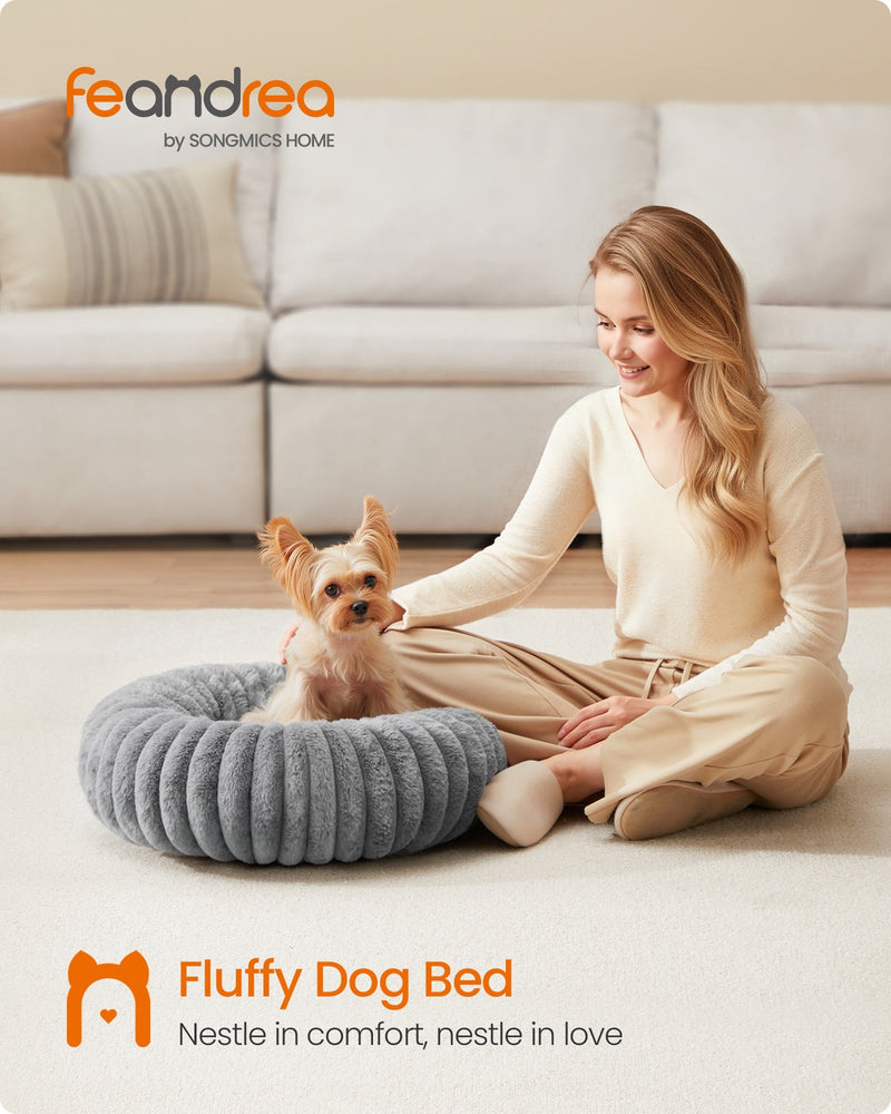 Lifestyle photo of a small dog resting in the Feandrea dove grey pet bed beside its owner in a living room