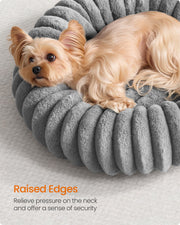 Close-up of a small dog leaning against the raised rim edge of the Feandrea dove grey pet bed