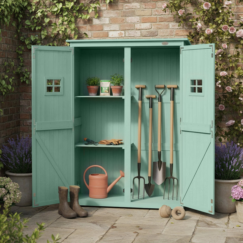 Green shed against a brick wall with potted plants on the roof and garden tools stored inside