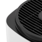 Close-up of the black top grille on the white air purifier body