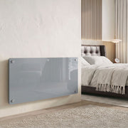 Grey glass panel heater wall-mounted in a modern bedroom