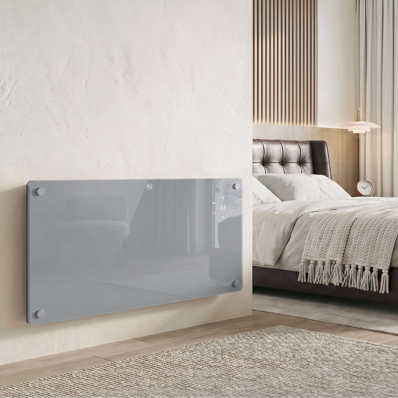 Grey glass panel heater wall-mounted in a modern bedroom