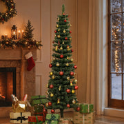Snow-dipped tree with red and gold baubles beside a fireplace, stockings and wrapped gifts