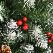 Close-up of red berries, snow-dipped tips and a pine cone on the branches