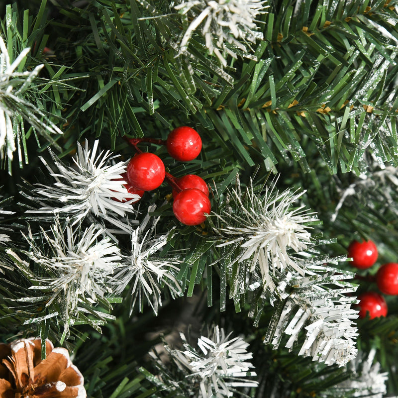 Close-up of red berries, snow-dipped tips and a pine cone on the branches