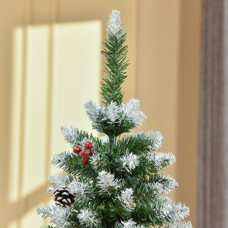 Close-up of the snow-tipped top of the tree with red berries and a pine cone