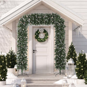Christmas tree arch framing a front door with a wreath on a snowy porch