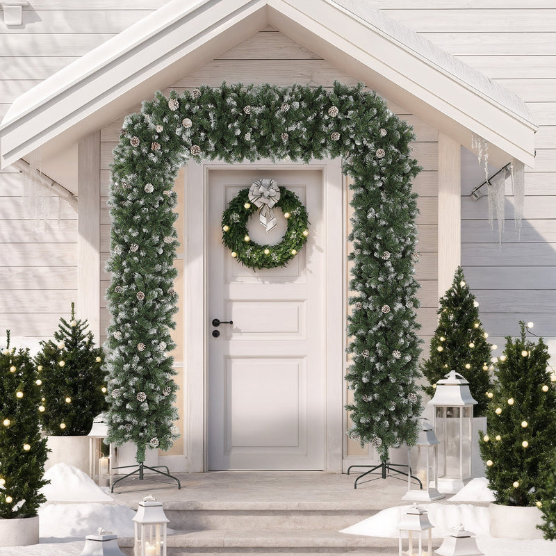 Christmas tree arch framing a front door with a wreath on a snowy porch