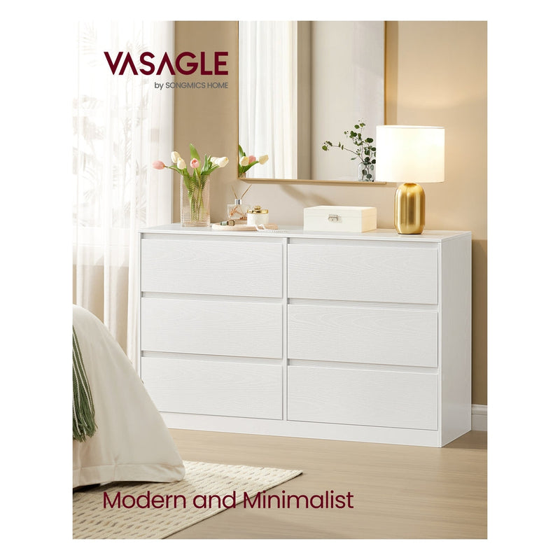 Snow White 6 drawer dresser in a bedroom with a gold lamp, mirror and flowers on top