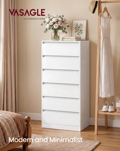 White tall chest of drawers in a bedroom beside a clothes rail and bed