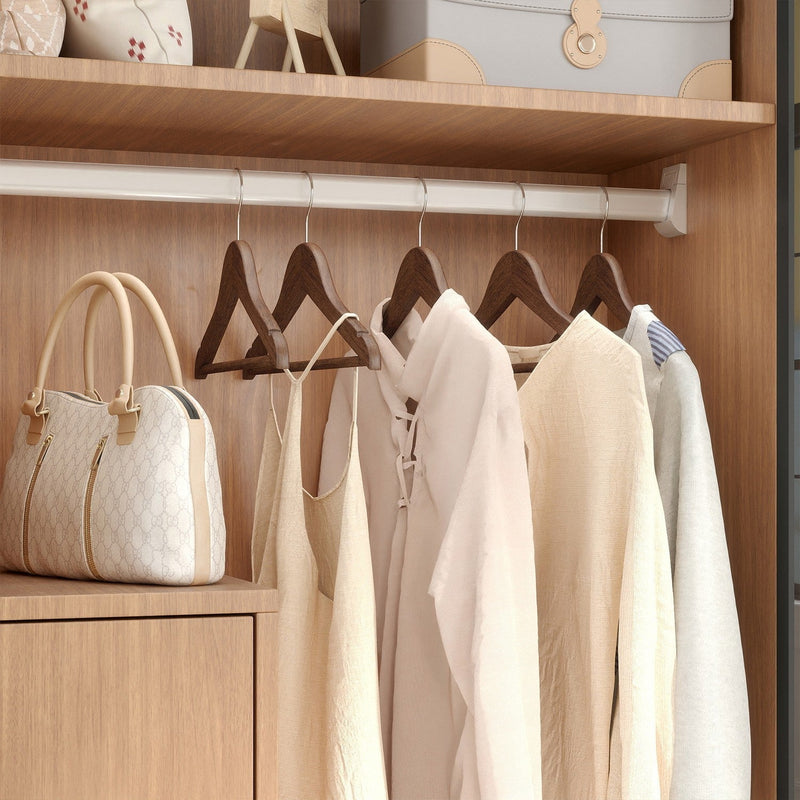 Wardrobe rail fitted with dark walnut wood hangers holding folded and hung clothes