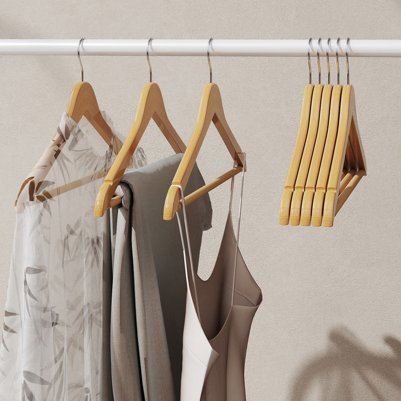 Close-up of the maple wood hangers holding shirts and dresses with spare hangers stacked alongside