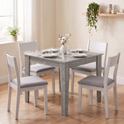 Dining table styled with white dining chairs, place settings and flowers