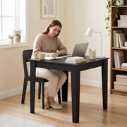 Black Wood Effect dining table used as a home workspace with a laptop and desk lamp