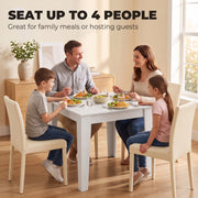 Family of four eating a meal at the white dining table