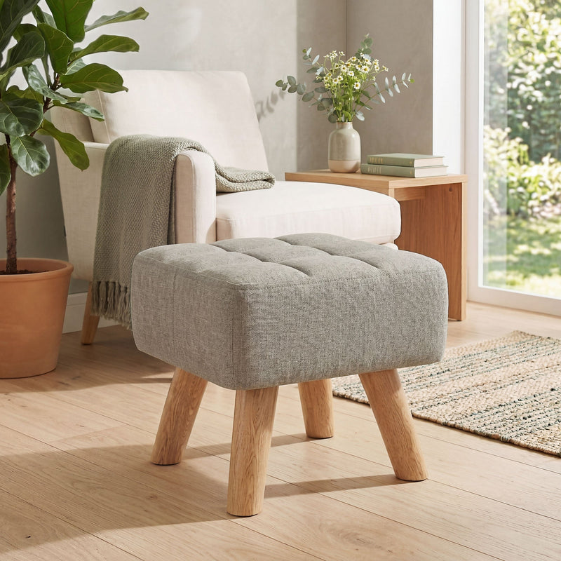 Footstool positioned in front of an armchair in a bright, plant-filled living room