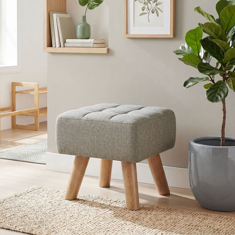 Footstool in a hallway nook beside a low shelf and potted plant