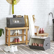 Grey storage box on a hallway bench under a brick wall with bags and an umbrella