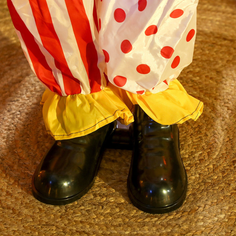 Close-up of the black boots and polka-dot trouser cuffs on the bottom clown figure