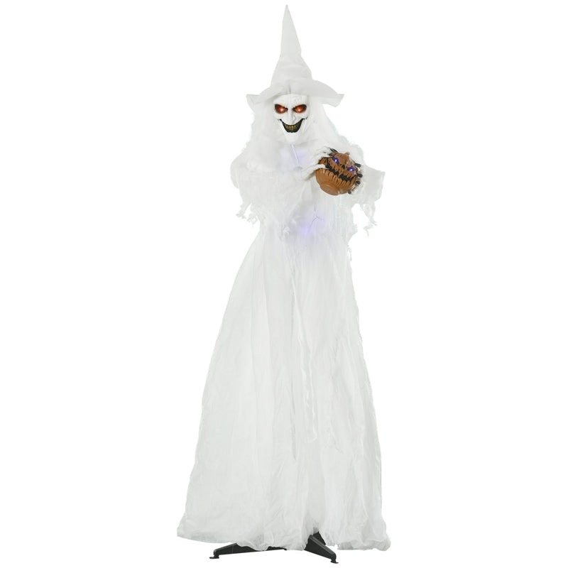 Standing white Halloween witch in a long gown holding a small carved pumpkin