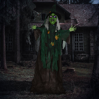 Standing green witch prop outside a dark wooden house at night