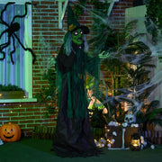 Standing green witch prop beside pumpkins and cobwebs on a decorated brick porch