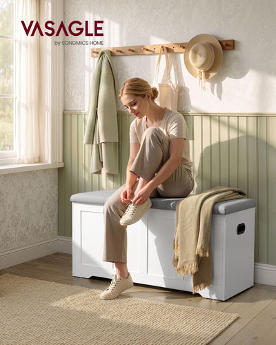 Woman sitting on the white and grey storage bench in a hallway to put on her shoes
