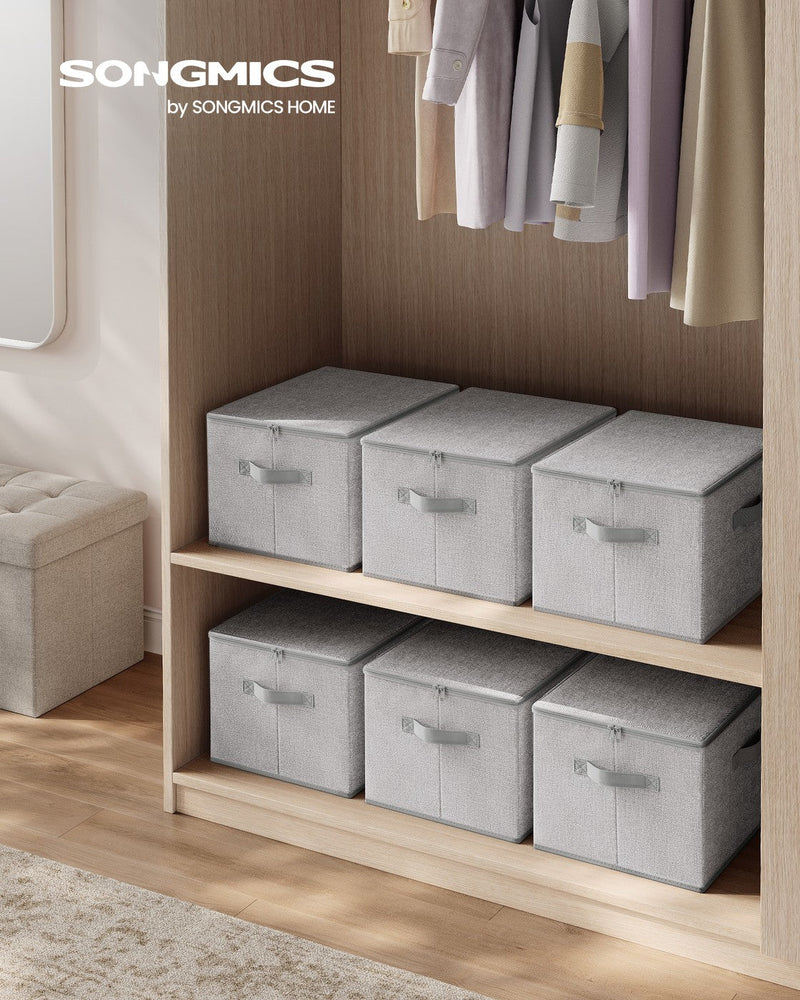 Six dove grey storage boxes with zipped lids arranged on a wardrobe shelf next to hanging clothes