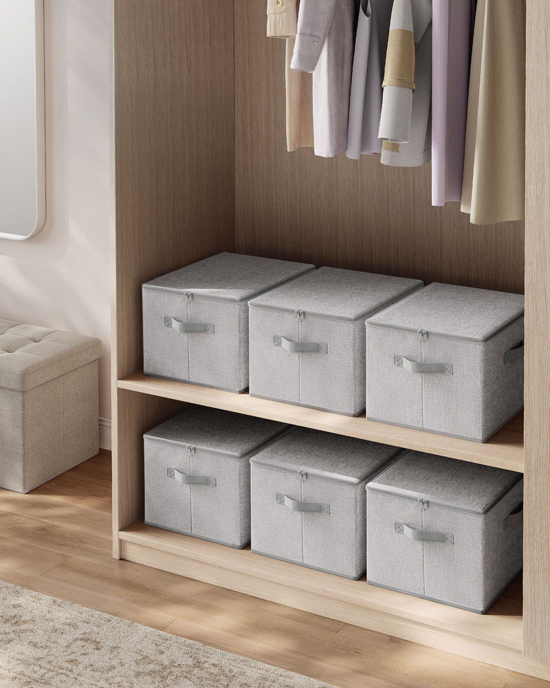 Six dove grey storage boxes with zipped lids arranged on a wardrobe shelf next to hanging clothes