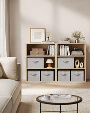Dove grey storage boxes fitted into open shelving in a living room alongside books and decor