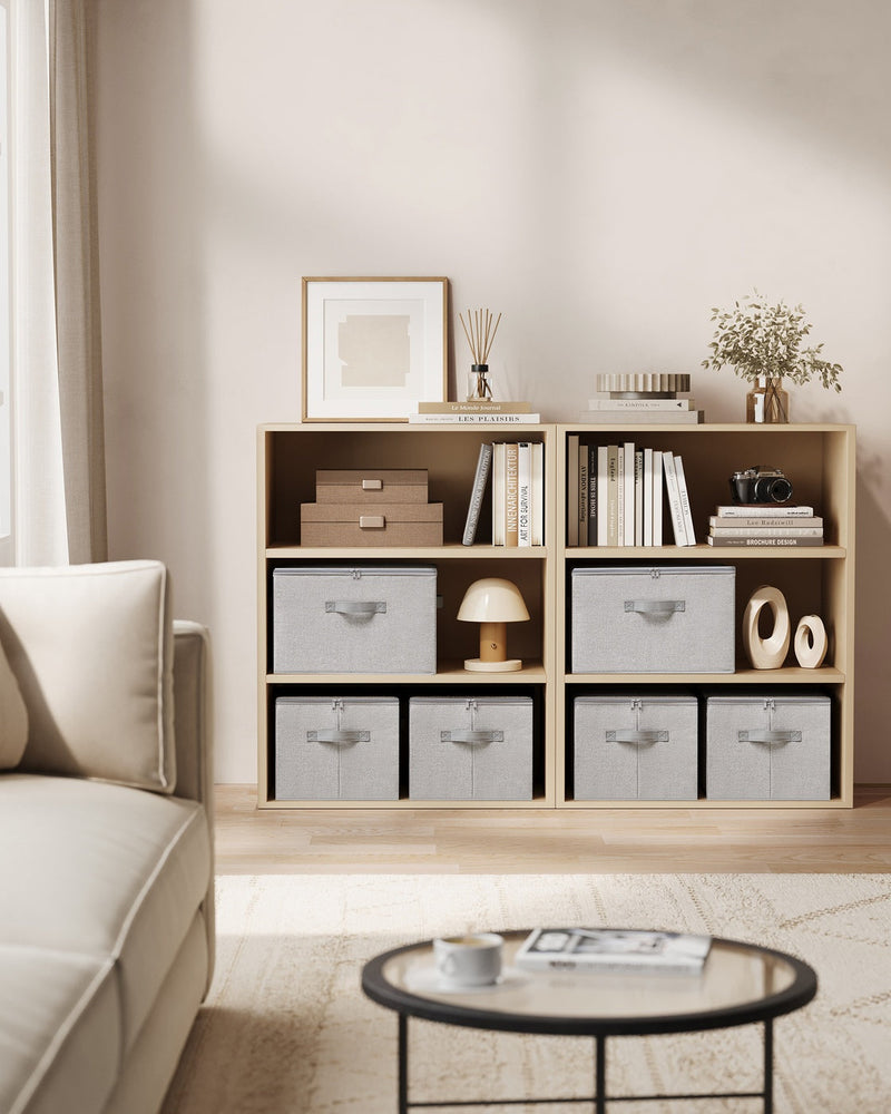 Dove grey storage boxes fitted into open shelving in a living room alongside books and decor