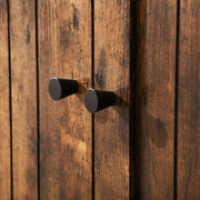 Close-up of the two black knobs on the wood-effect slat doors