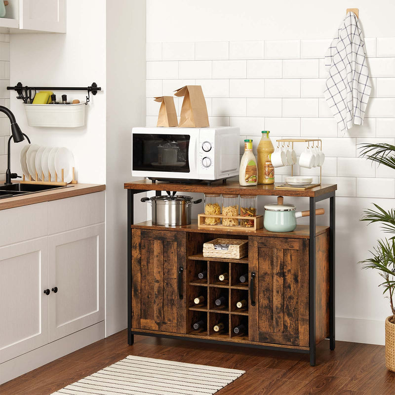 The cabinet in a kitchen holding a microwave, pans and bottles in the wine rack