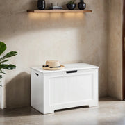 White storage chest bench against a plaster wall with a straw hat on the closed lid