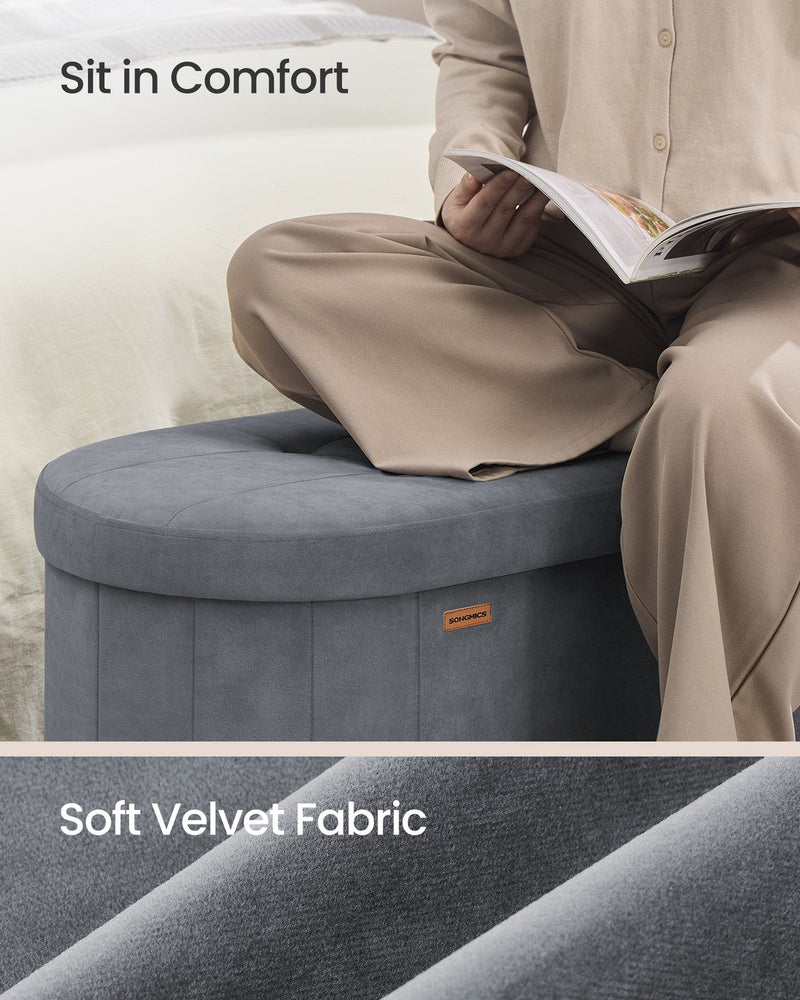 Person sitting cross-legged on the slate grey ottoman reading a magazine, with a close-up of the velvet fabric texture.