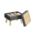Slate grey linen-look storage ottoman with wooden legs shown with its hinged lid lifted open to reveal books stored inside the hollow compartment.
