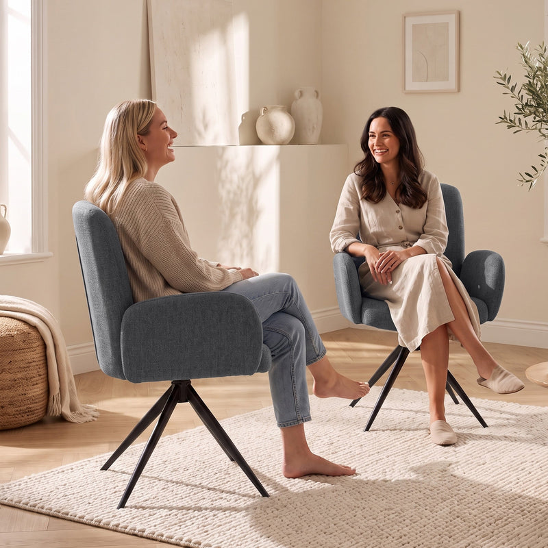 Two women chatting face to face in grey swivel accent chairs