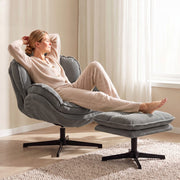 Woman reclining in the armchair with her legs resting on the footstool
