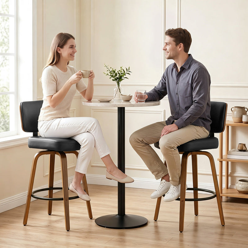 Couple sitting on the black swivel bar stools at a bar table