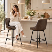 Woman holding a mug on a dark brown bar stool at a kitchen island