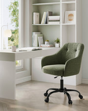 Green swivel chair in a study corner with white shelving and a desk lamp