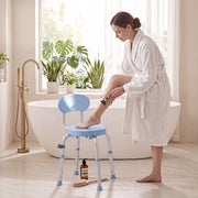 Woman in a robe resting her foot on the light blue shower chair beside a freestanding bath