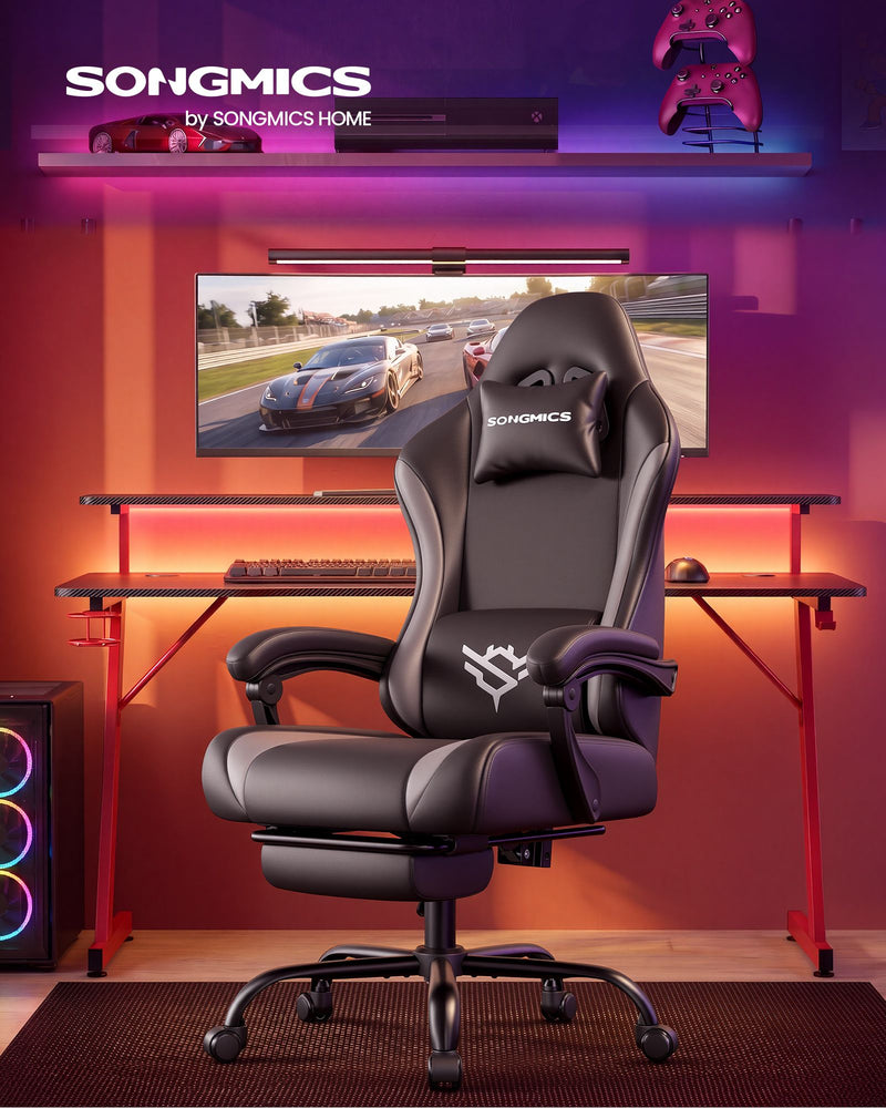 Gaming chair with footrest at a desk in a purple and orange lit gaming room