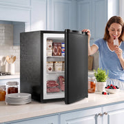 Woman taking an ice lolly from the open mini freezer on a kitchen counter