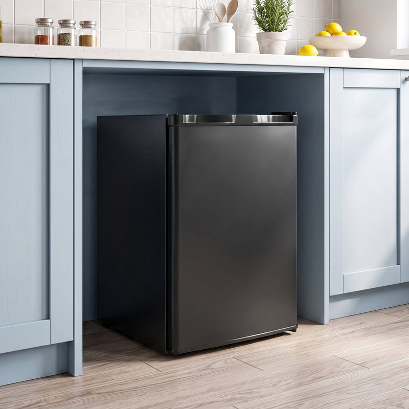 Compact freezer fitted under a kitchen worktop between cupboards