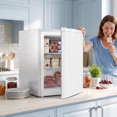 Mini freezer on a kitchen worktop with the door open and frozen food stacked inside